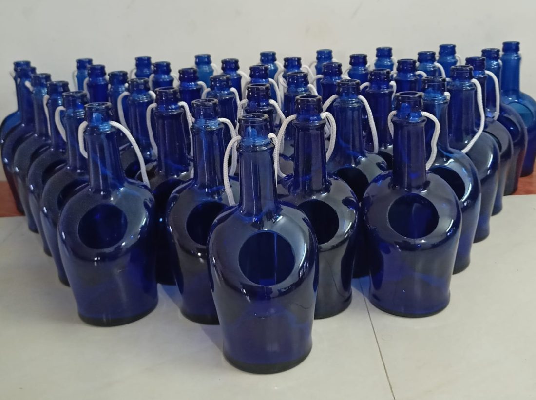Rows of blue glass bottles cut and hung as chimes